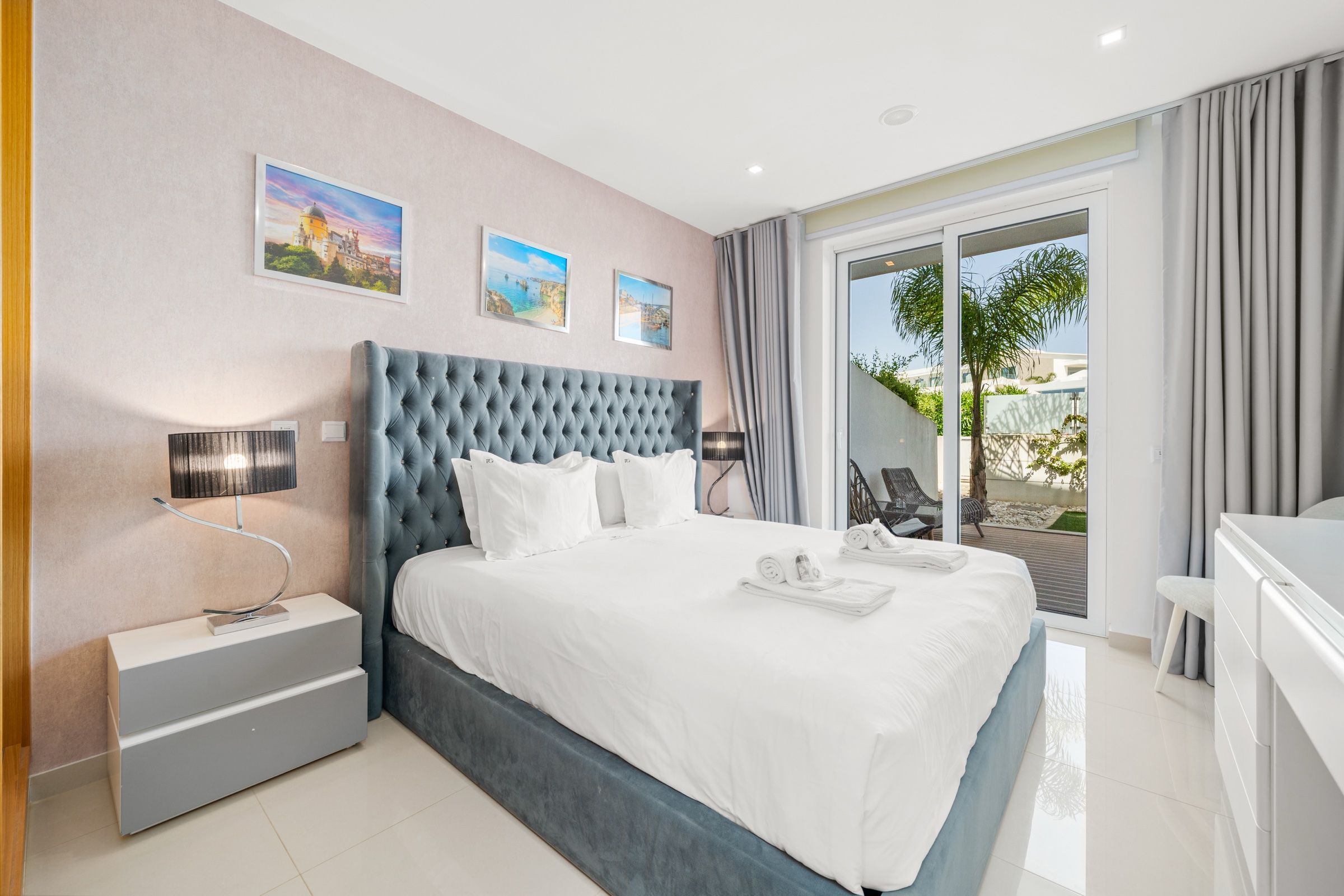 Double bedroom with a grey-blue tufted headboard and a door to the garden
